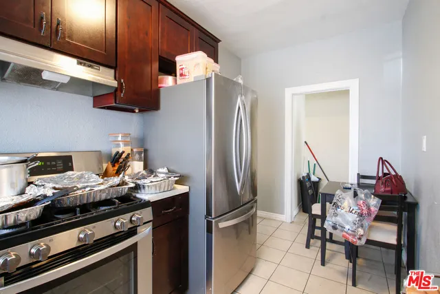 a kitchen with stainless steel appliances granite countertop a refrigerator and a stove top oven