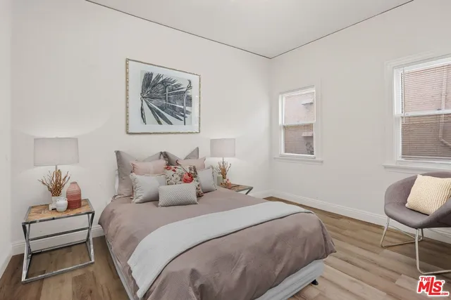 a bedroom with bed and a painting on the wall