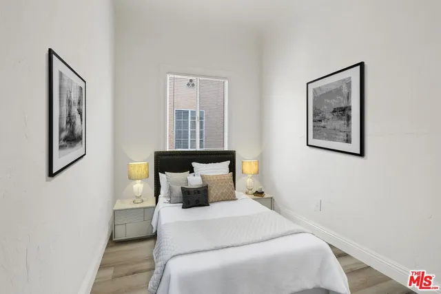 a bedroom with a large bed and wooden floor