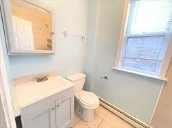a bathroom with a sink a toilet and a window