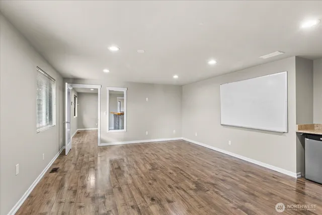 a view of empty room with wooden floor