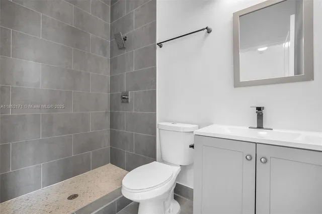 a view of an empty room with wooden floor and window