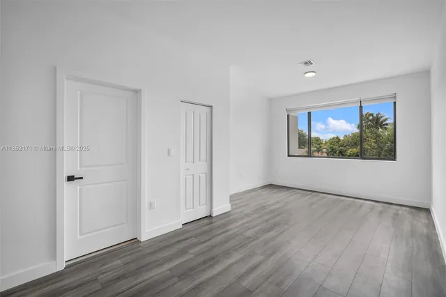 a view of a room with wooden floor