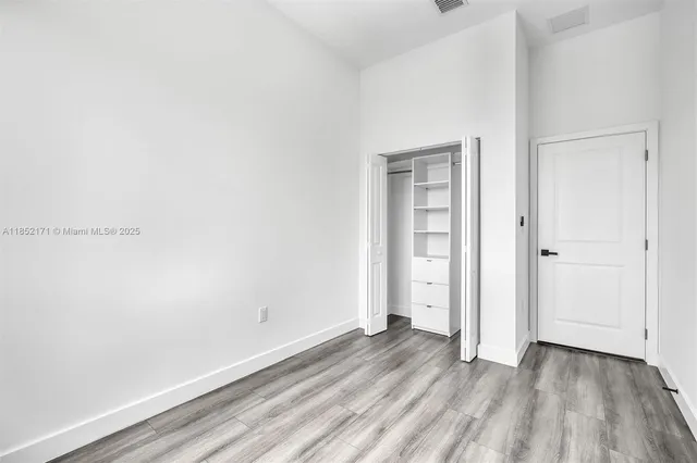 an empty room with wooden floor and window