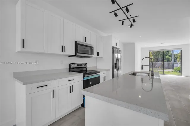 a kitchen with stainless steel appliances a sink stove and cabinets