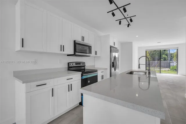 a kitchen with stainless steel appliances a sink stove and cabinets