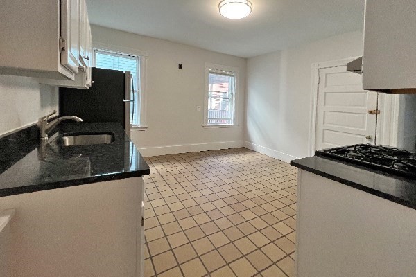 40 Calvin Street, Unit 2 Somerville, MA 02143 - Photo 6 of 12 a kitchen with stainless steel appliances granite countertop a stove and a refrigerator