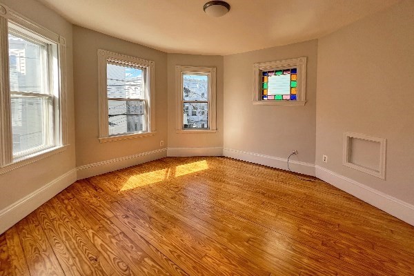 40 Calvin Street, Unit 2 Somerville, MA 02143 - Photo 10 of 12 an empty room with wooden floor and windows