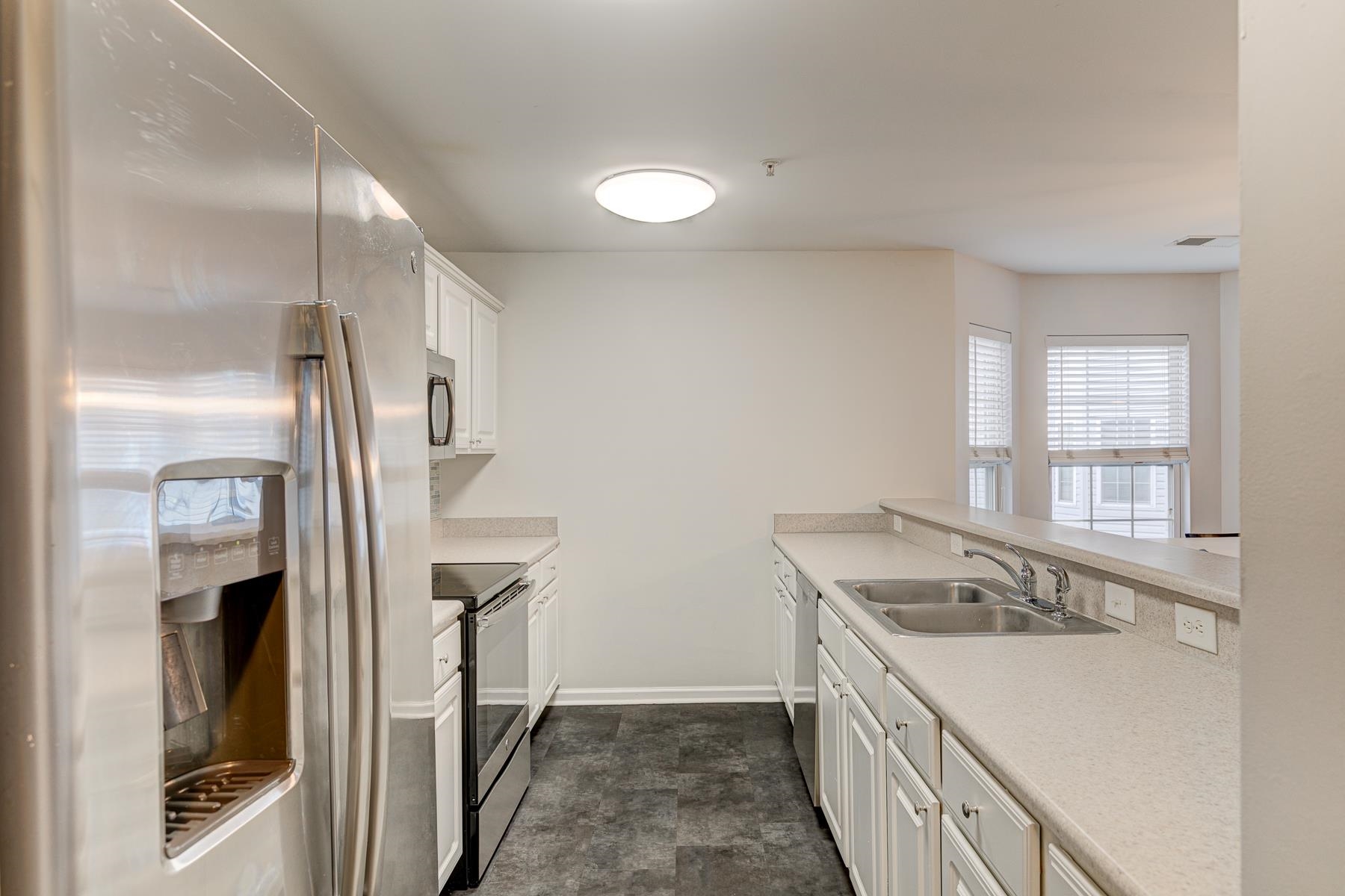 4826 Innisbrook Court, Unit 905 Myrtle Beach, SC 29579 - Photo 6 of 36 Kitchen with appliances with stainless steel finishes, white cabinets, light countertops, and a peninsula