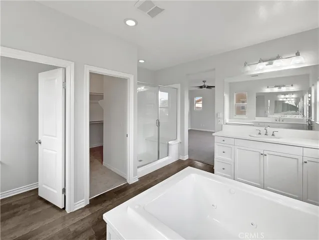 a spacious bathroom with a shower a sink and a mirror
