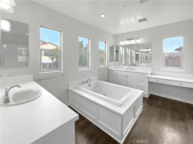 a bathroom with a tub sink and mirror
