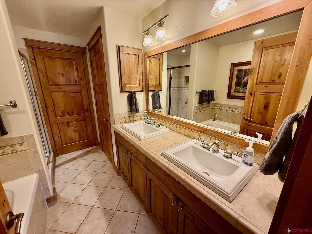 9 Hunter Hill Road, Unit 205 Crested Butte, CO 81225 - Photo 16 of 28 a spacious bathroom with a sink a mirror and a shower