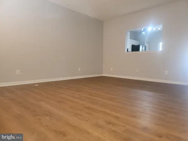 an empty room with a fireplace cabinet and windows