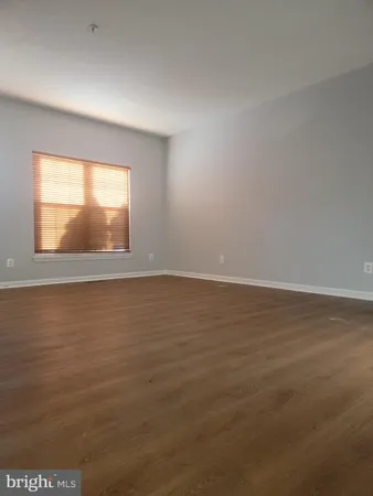 a view of a kitchen with wooden floor and a refrigerator