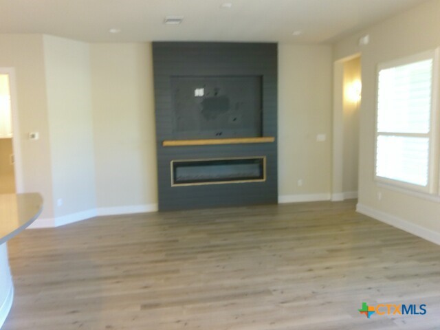 791 Hazy Hills Loop Dripping Springs, TX 78620 - Photo 21 of 44 a view of an empty room with wooden floor and a window