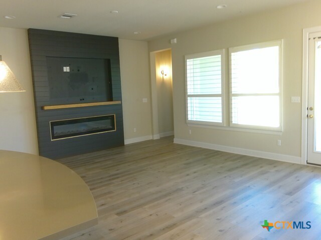 791 Hazy Hills Loop Dripping Springs, TX 78620 - Photo 22 of 44 a view of an empty room with wooden floor and a window