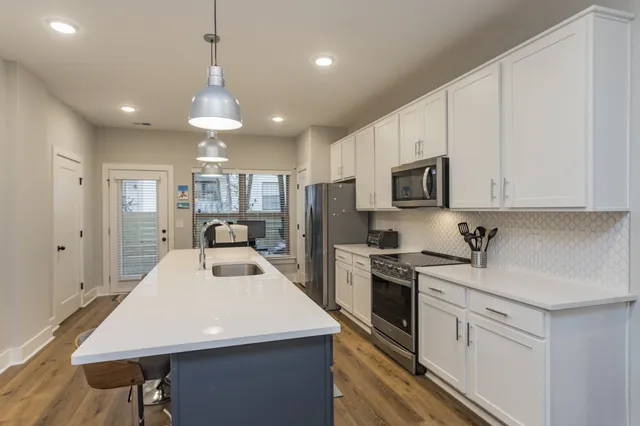 a kitchen with kitchen island appliances cabinets and furniture