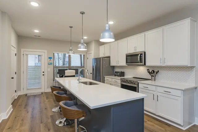 a kitchen that has a lot of cabinets and wooden floor
