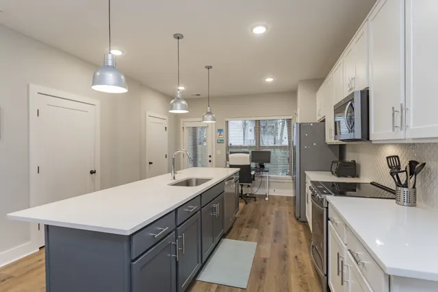 a kitchen with a sink a counter top space stainless steel appliances and cabinets
