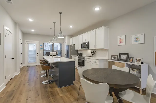 a kitchen with a table chairs refrigerator and microwave