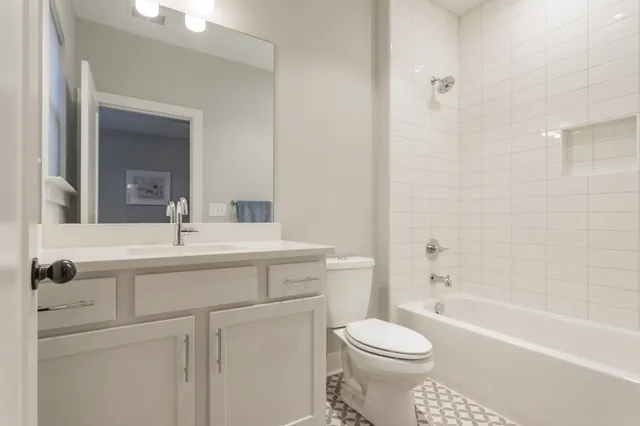 a bathroom with a sink toilet vanity and tub