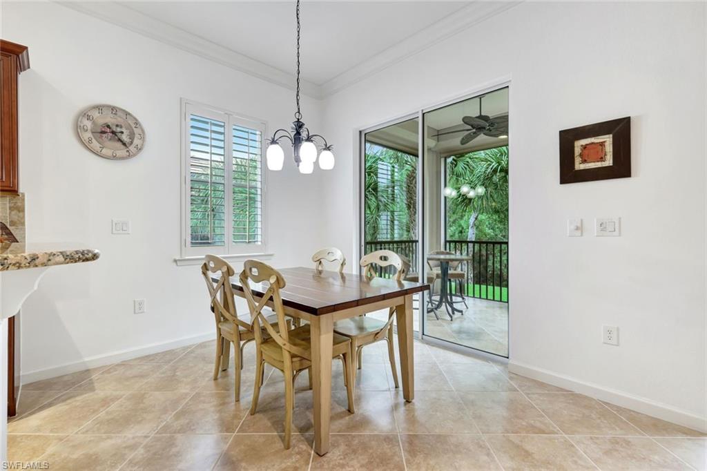 9508 Ironstone Terrace, Unit 201 Naples, FL 34120 - Photo 18 of 45 Dining room with healthy amount of natural light, ornamental molding, a chandelier, and light tile patterned floors