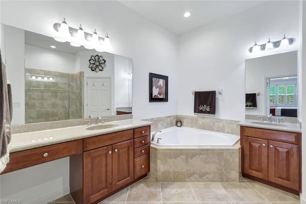 9508 Ironstone Terrace, Unit 201 Naples, FL 34120 - Photo 22 of 45 Full bath with a shower stall, two vanities, a garden tub, light tile patterned flooring, and recessed lighting