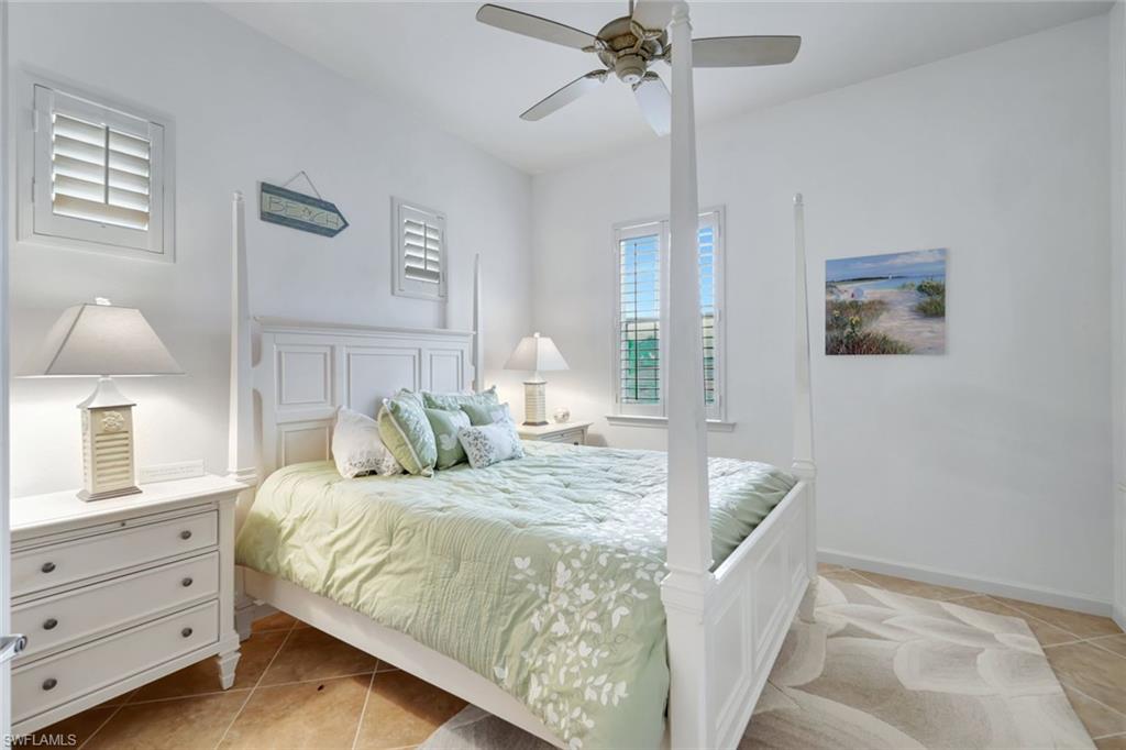 9508 Ironstone Terrace, Unit 201 Naples, FL 34120 - Photo 24 of 45 Bedroom with light tile patterned floors and ceiling fan