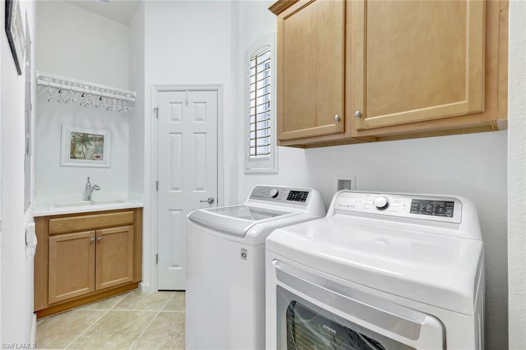 9508 Ironstone Terrace, Unit 201 Naples, FL 34120 - Photo 29 of 45 Laundry area featuring cabinet space, light tile patterned flooring, and washer and clothes dryer