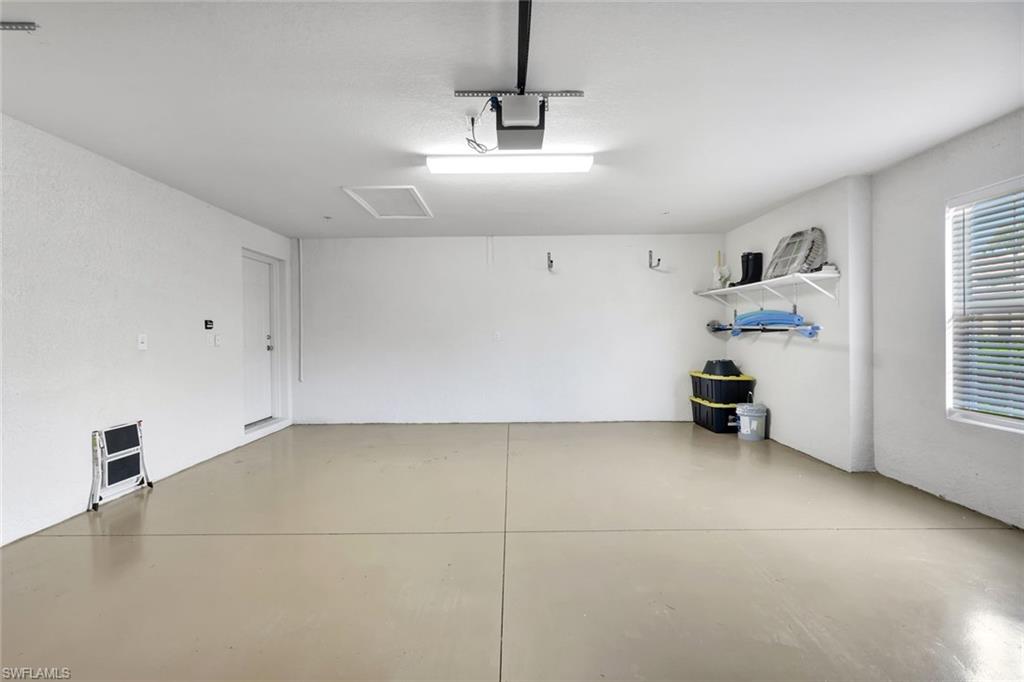 9508 Ironstone Terrace, Unit 201 Naples, FL 34120 - Photo 30 of 45 Garage featuring a garage door opener