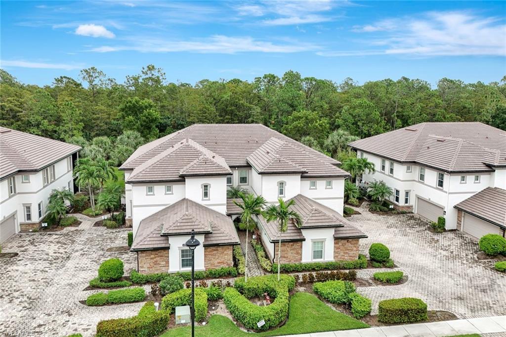 9508 Ironstone Terrace, Unit 201 Naples, FL 34120 - Photo 35 of 45 View of front of property with decorative driveway, stucco siding, and stone siding