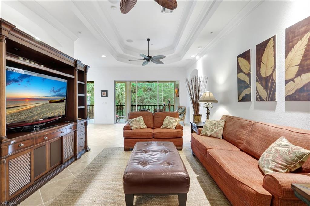 9508 Ironstone Terrace, Unit 201 Naples, FL 34120 - Photo 7 of 45 Living room with ornamental molding, a tray ceiling, light tile patterned floors, and recessed lighting