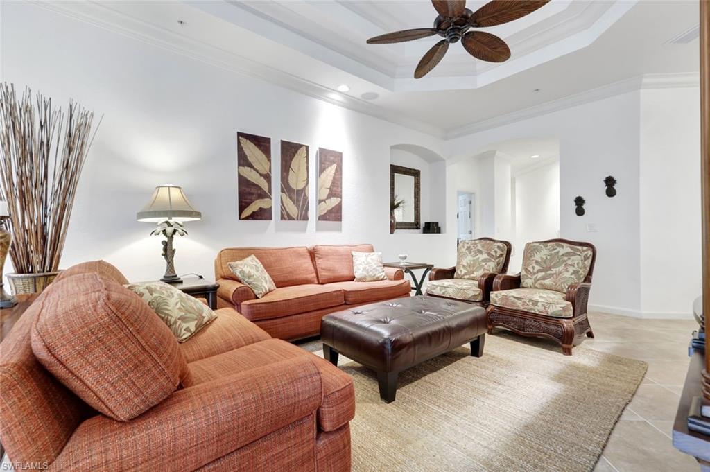 9508 Ironstone Terrace, Unit 201 Naples, FL 34120 - Photo 9 of 45 Tiled living room featuring a raised ceiling, ornamental molding, ceiling fan, recessed lighting, and arched walkways