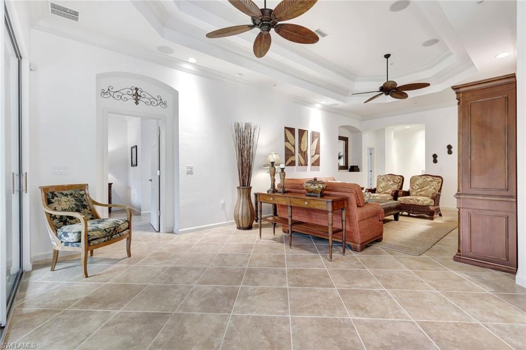 9508 Ironstone Terrace, Unit 201 Naples, FL 34120 - Photo 10 of 45 Living area featuring crown molding, a raised ceiling, arched walkways, ceiling fan, and light tile patterned floors