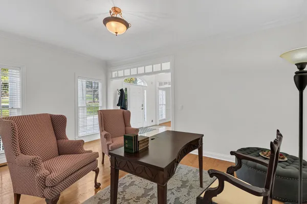 a living room with furniture a fireplace and a chandelier