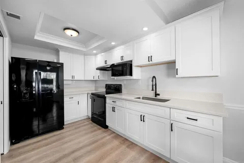 a kitchen with a sink stainless steel appliances and cabinets