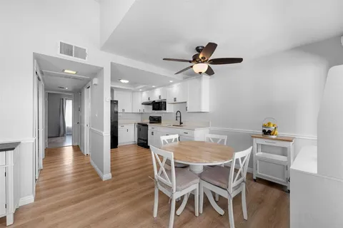 a view of a dining room with furniture and a chandelier