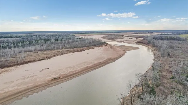 a view of a dry yard with wooden fence