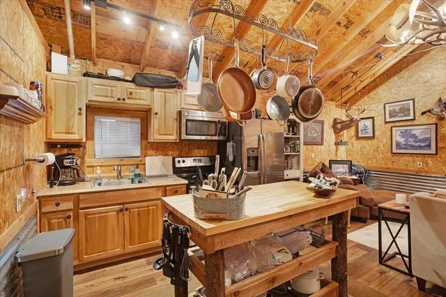 a kitchen with stainless steel appliances a stove a sink dishwasher and cabinets with wooden floor