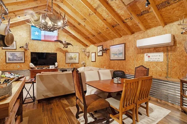 a living room with furniture a flat screen tv and kitchen view
