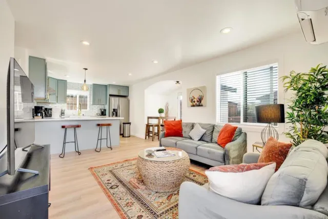 a living room with stainless steel appliances kitchen island granite countertop furniture and a flat screen tv