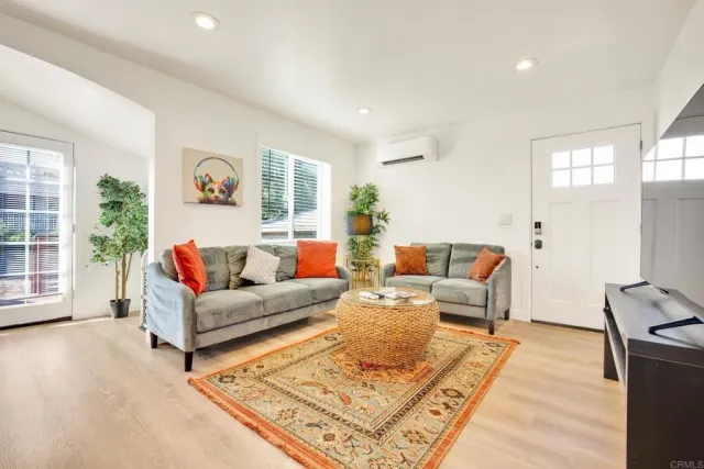 a kitchen with stainless steel appliances granite countertop a refrigerator a stove a dining table and chairs with wooden floor