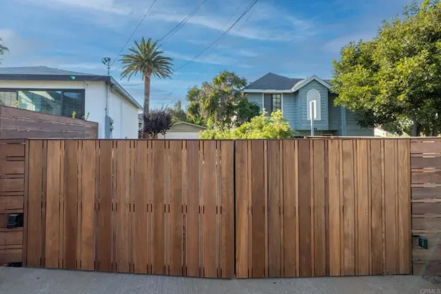 a view of a house with wooden fence