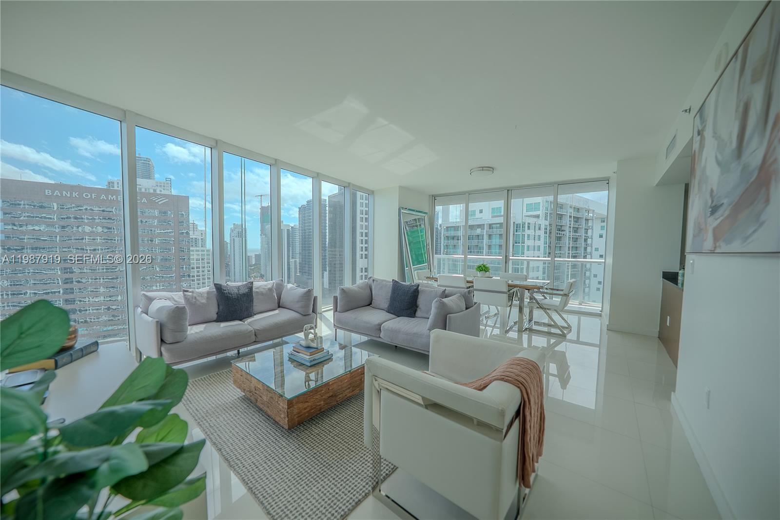 a living room with furniture and a floor to ceiling window
