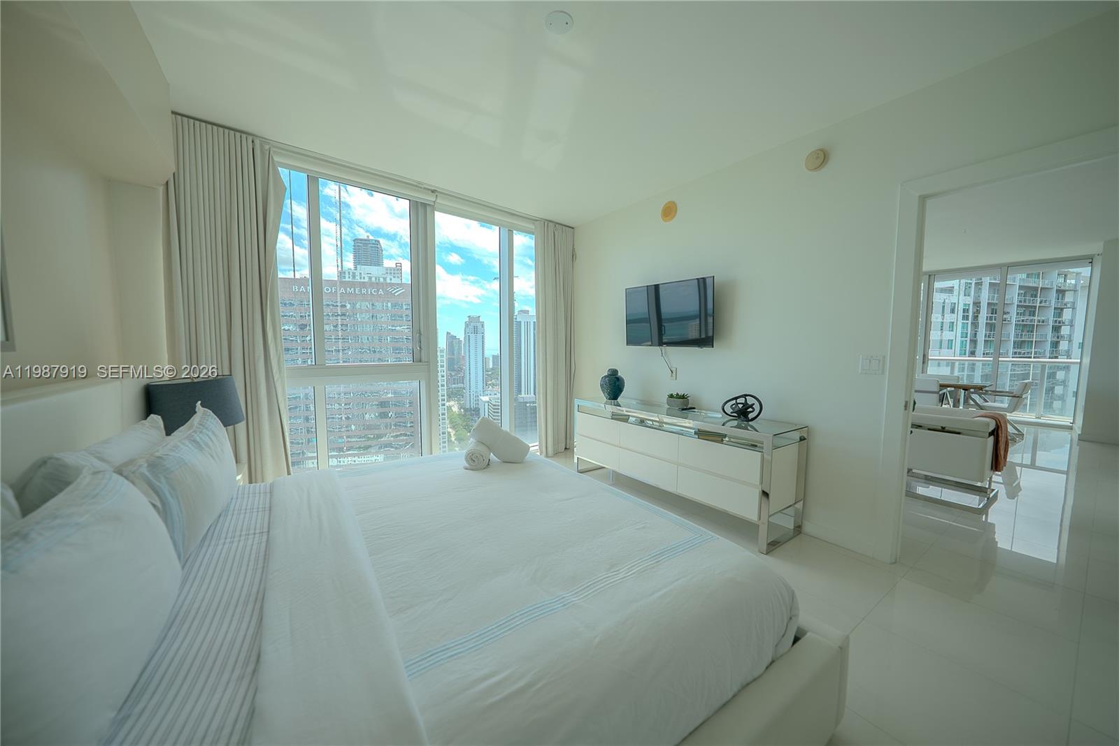 Icon Brickell Miami, FL 33131 - Photo 19 of 26 a large white bed sitting in a room next to a window
