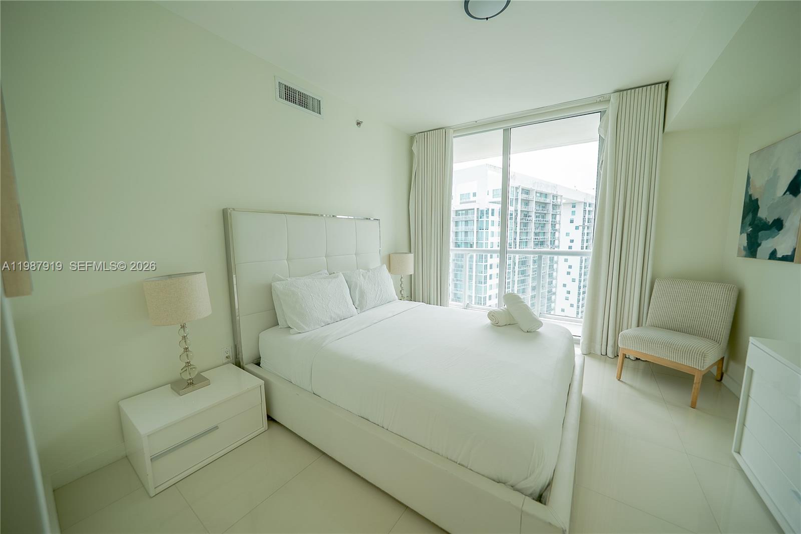 Icon Brickell Miami, FL 33131 - Photo 4 of 26 a bedroom with a bed and a chair