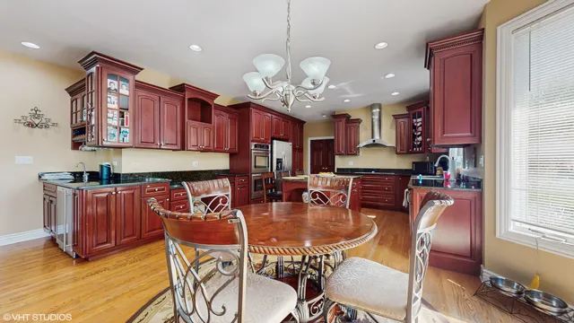 a dining room filled chandelier and wooden furniture