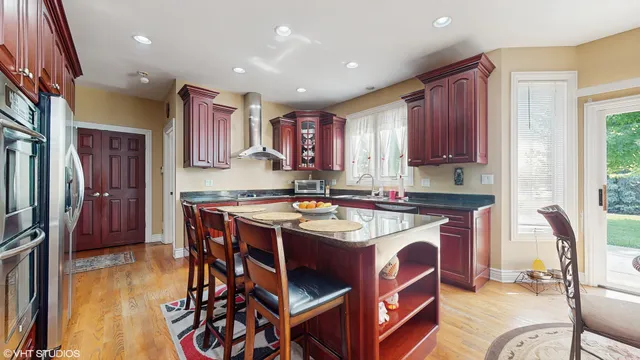 a kitchen that has a table chairs in it and wooden floors