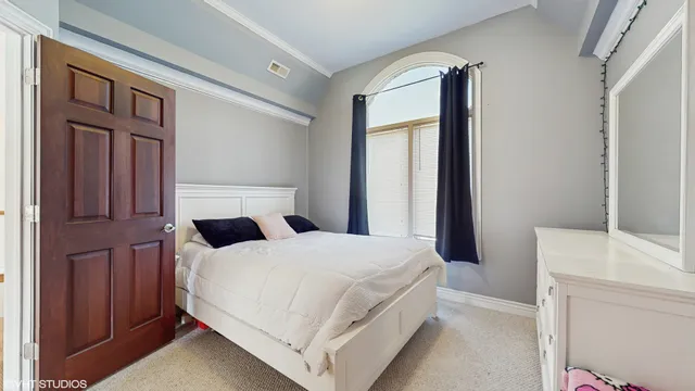 a bedroom with a large bed and wooden floor