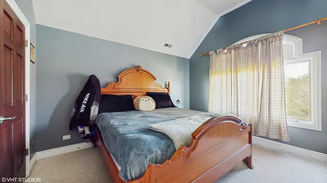 a bedroom with a bed and flat tv screen on the dresser